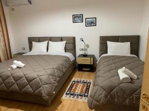 dos camas sentadas una al lado de la otra en un dormitorio en Hotel Relax, en Gjirokastra
