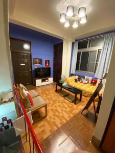 Una sala de estar con un sofá y un televisor. en HouseNandoor, en Tainan