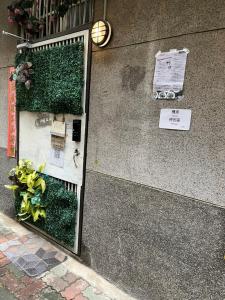 a mirror on the side of a building with plants at HouseNandoor in Tainan
