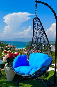 uma cadeira de baloiço com almofadas azuis num pátio em Hotel Two Mermaids Ksamil em Ksamil