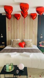 een slaapkamer met rode harten boven een bed bij Cosy Spa Grigny in Grigny