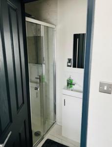 a bathroom with a glass shower and a sink at Wadhurst - Stunning 4 bed (all en-suite) house in Aveley