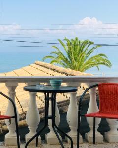 羅達的住宿－Kappa & Lamda Apartments，一张桌子和椅子,享有海滩美景