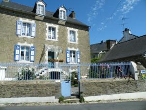 a brick building with a fence in front of it at Les Gîtes Cancalais in Cancale