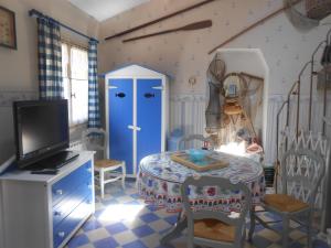une chambre avec une table et une porte bleue dans l'établissement Les Gîtes Cancalais, à Cancale