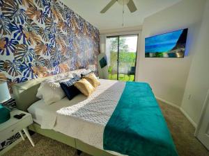a bedroom with a large bed with a colorful wall at Tropical Breeze - 2BR/NRG/Medical Center/Galleria in Houston
