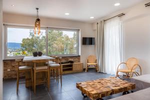 a living room with a table and chairs and a large window at Konstantino's Corfu Marina View Apartment in Kontokali