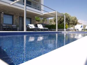 a swimming pool in front of a house at MIROS MARE STUDIOS in Agia Galini