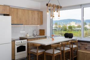 a kitchen with a kitchen island with bar stools at Konstantino's Corfu Marina View Apartment in Kontokali