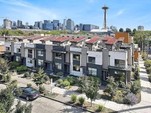 an apartment building with a car parked in front of a city at Deactivated- Rooftop Patio with Grill 2BR 3BA Central, Walkable Location in Seattle