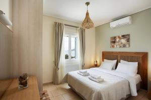 a bedroom with a bed with two towels on it at Aithra -Agios Petros Andros in Gavrio