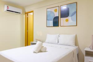 a bedroom with a white bed with two towels on it at Conforto à beira mar! Apartamento com vista para o mar. in Angra dos Reis