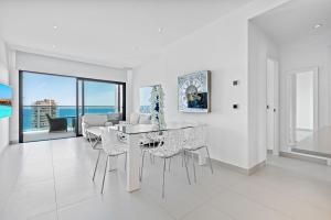 a white dining room with a table and chairs at Sunset Drive Resort Apartment 5-10 Poniente Beach in Benidorm