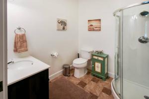 y baño con aseo, lavabo y ducha. en Safari Cottage, en Jacksonville