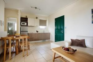 a kitchen and living room with a table and a couch at Aithra -Agios Petros Andros in Gavrio