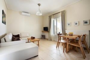 a living room with a white couch and a table at Aithra -Agios Petros Andros in Gavrio
