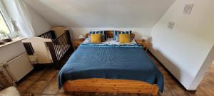 Schlafzimmer mit einem Bett mit blauen und gelben Kissen in der Unterkunft Urlaub auf dem Bauernhof in Netphen