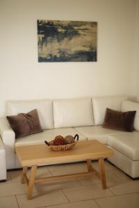 a couch with a bowl of fruit on a coffee table at Aithra -Agios Petros Andros in Gavrio