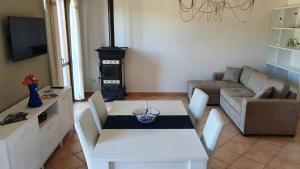a living room with a white table and a couch at Delizioso appartamento a Capalbio con vista in Capalbio