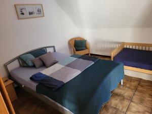 1 dormitorio con 1 cama grande y 1 silla en Urlaub auf dem Bauernhof, en Netphen