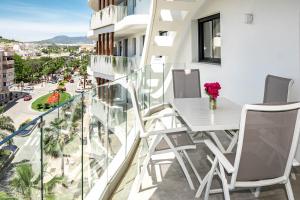 a balcony with a table and chairs and a view of a city at INF45P- modern 3 bed city apartment next to beach in Estepona