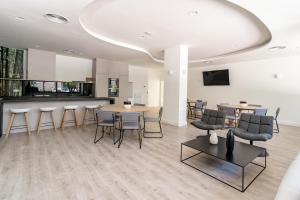 a room with tables and chairs and a bar at INF45P- modern 3 bed city apartment next to beach in Estepona
