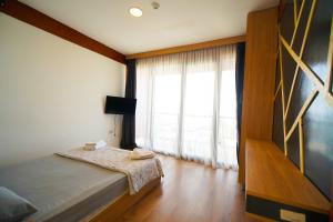 1 dormitorio con cama y ventana grande en QCUNDA OTEL en Ayvalık