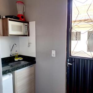 a small kitchen with a microwave and a sink at Flat Temporada in Carolina
