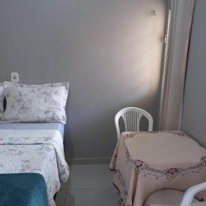 a small bedroom with a bed and a chair at Flat Temporada in Carolina