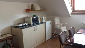 a small kitchen with a microwave on a counter at Hanna Szobái in Tarcal