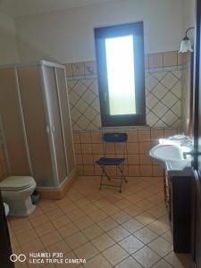 a bathroom with a toilet and a sink and a window at Case vacanze Baglio Sances in Birgi Vecchi