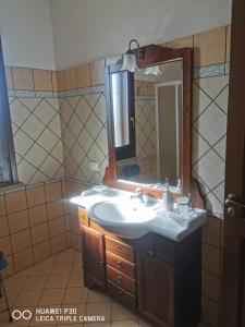 a bathroom with a sink and a mirror at Case vacanze Baglio Sances in Birgi Vecchi