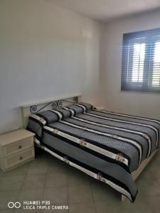 ビルジ・ヴェッキにあるCase vacanze Baglio Sancesのベッドルームのベッド(ストライプ毛布付)