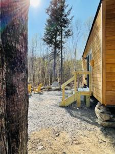 a log cabin with a bench next to a tree at Trailside Stays in Rumney