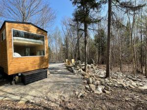 a tiny house sitting in the middle of a forest at Trailside Stays in Rumney
