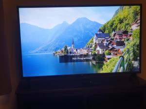 a television screen with a picture of a town and a lake at Right Choice Studio in Antwerp