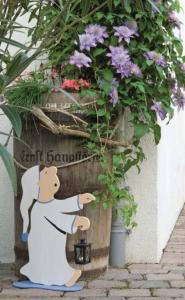 una figurita de un chef apuntando a un cartel con flores en Pension Gästehaus Kachelofa, en Vaihingen an der Enz