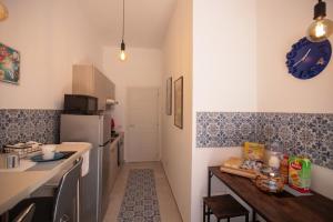 a small kitchen with a table and a refrigerator at Sipario in Castellammare di Stabia