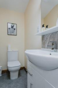 a white bathroom with a toilet and a sink at Cosy 2nd Floor Apartment - King Size Bed & Free Parking in Nottingham