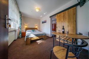 een slaapkamer met een bed en een tafel met een fles wijn bij Willa Arkadia in Pobierowo