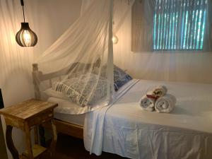 een slaapkamer met een bed met twee knuffels erop bij Casa no coração da vila de Caraiva in Caraíva