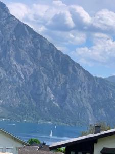 a view of a lake with a sail boat in the distance at Traum Panorama Apartment mit Berg & Seeblick in Altmünster