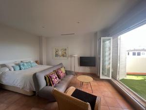 - une chambre avec un lit, un canapé et une télévision dans l'établissement Híspalis Casa Palacio Ático, à Séville