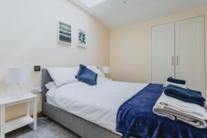 a bedroom with a bed with blue sheets and a desk at Spacious 2nd Floor Apartment - King Size Bed & Free Parking in Nottingham
