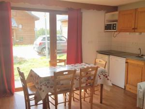 een keuken met een tafel en stoelen en een keuken met een raam bij Appartement La Joue du Loup, 2 pièces, 6 personnes - FR-1-504-482 in Le Dévoluy