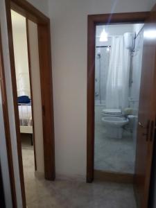 een badkamer met een toilet, een wastafel en een spiegel bij Casa da nonna Carmela in Montecorice