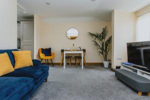 a living room with a blue couch and a table at Spacious 2nd Floor Apartment - King Size Bed & Free Parking in Nottingham