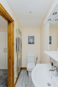 a white bathroom with a toilet and a sink at Spacious 2nd Floor Apartment - King Size Bed & Free Parking in Nottingham