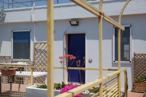 a white house with a blue door and flowers at Salento Sea & Sun Apartment in Porto Cesareo