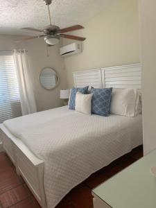 a bedroom with a bed with a ceiling fan at Flamboyant Beach House in Saint James